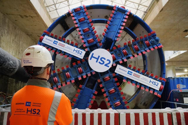 <p>A HS2 worker stands in front of a tunnel boring machine (Jonathan Brady/PA)</p>
