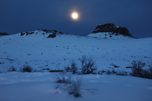<p>The moon rises over a snow covered hill after recent storms in February of last year near Mammoth Lakes, California. The snow moon is also known as the storm moon</p>