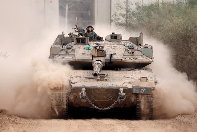 <p>An Israeli army tank drives into position near Israel's southern border with the Gaza Strip</p>