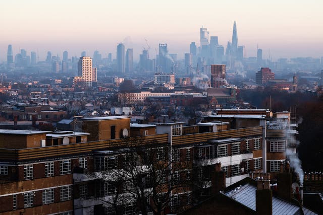 <p>Residential buildings in the Brixton suburb of south London and the buildings of the City of London financial district (behind) are seen on a cold and frosty morning as the sun rises over the capital on January 10, 2025. </p>