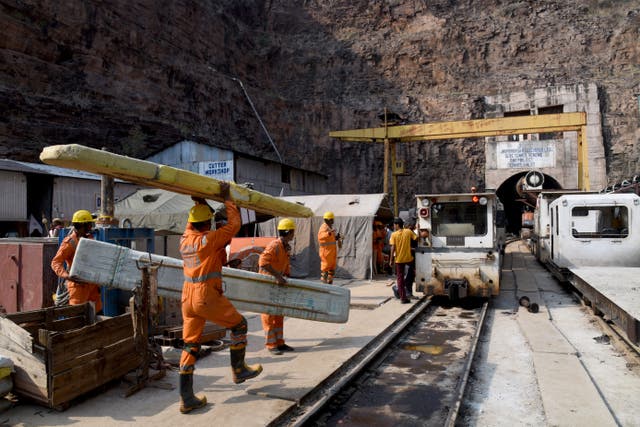 <p>National Disaster Response Force personnel carry their equipment during a rescue operation outside the Srisailam Left Bank Canal tunnel in Telangana, India</p>