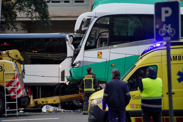 <p>Firefighters and police officers stand next to a bus after two buses collided in Barcelona</p>