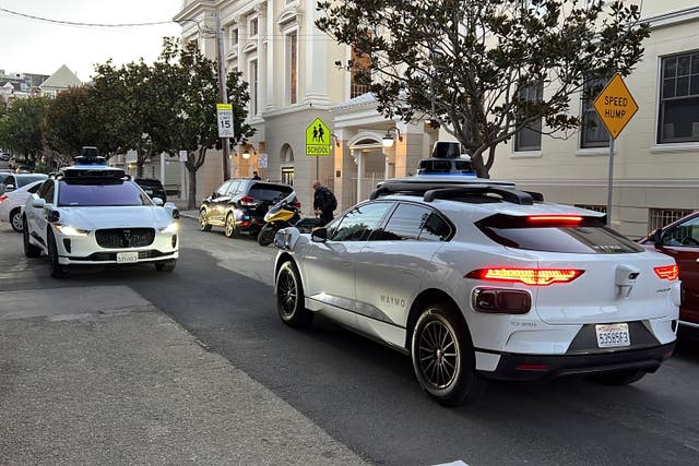 <p>Two Waymo robotaxis on a San Francisco street</p>